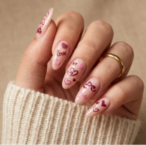 elegant pink almond-shaped nails with red heart outlines, love lettering, and cute romantic designs.